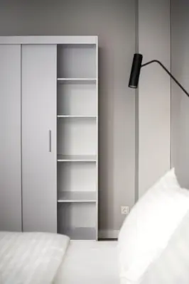a bedroom with a closet with a bed and a lamp at #stayhere Modern & Compact 1BDR Uptown Vilnius in Vilnius