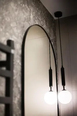 a bathroom with three lights and a mirror at #stayhere Modern & Compact 1BDR Uptown Vilnius in Vilnius