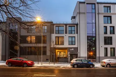 three cars parked in a parking lot in front of a building at #stayhere Modern & Compact 1BDR Uptown Vilnius in Vilnius