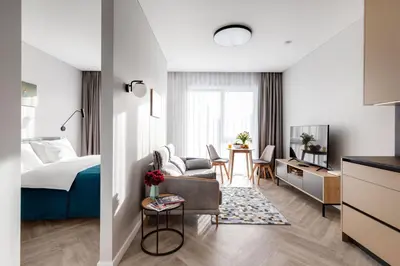 a hotel room with a bed and a living room at #stayhere Modern & Compact 1BDR Uptown Vilnius in Vilnius