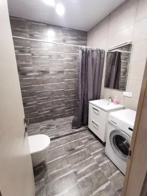 a bathroom with a toilet sink and a washing machine at K-Town - Apartments ViaBaltic Kaunas in Kaunas