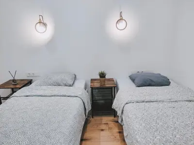 a bedroom with two beds and a side table at K-Town - Apartments ViaBaltic Kaunas in Kaunas