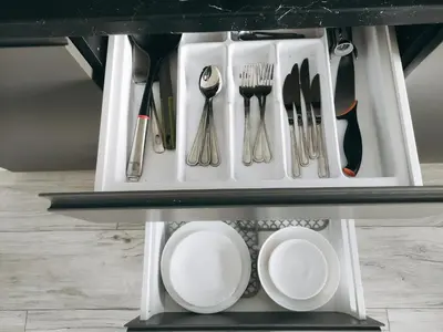 a shelf filled with utensils on a table at K-Town - Apartments ViaBaltic Kaunas in Kaunas