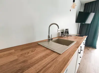 a kitchen with a sink on a wooden counter at K-Town - Apartments ViaBaltic Kaunas in Kaunas