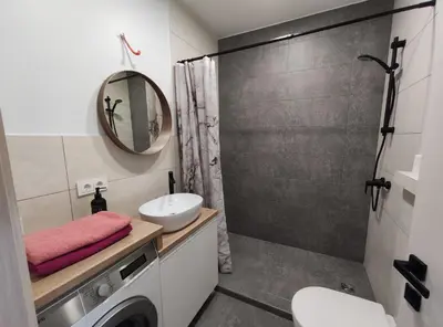 a bathroom with a sink and a washing machine at K-Town - Apartments ViaBaltic Kaunas in Kaunas
