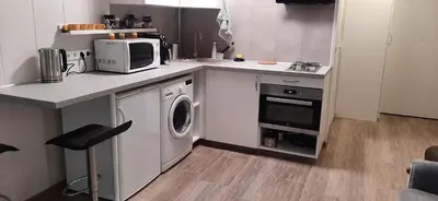 a kitchen with a washing machine and a microwave at Elite Flats One bedroom in Utena