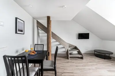 a dining room with a table and chairs and a staircase at Angel House Vilnius, Old Town 6 in Vilnius