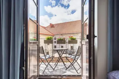 an open window with a table and chairs on a balcony at Angel House Vilnius, Old Town 6 in Vilnius