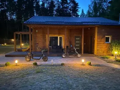a small cabin with scooters parked in front of it at ForrestVila in Karačiūnai