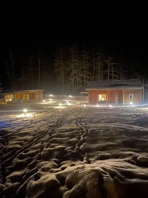 a snow covered parking lot at night with a building at ForrestVila in Karačiūnai