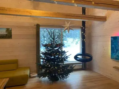 a christmas tree in a room with a window at ForrestVila in Karačiūnai