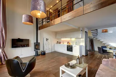 an open living room with a staircase and a living room at Loft 65 Panoramic View in Vilnius