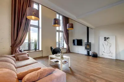 a living room with a couch and a table at Loft 65 Panoramic View in Vilnius