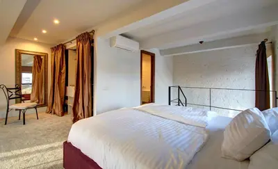 a bedroom with a large white bed and a chair at Loft 65 Panoramic View in Vilnius