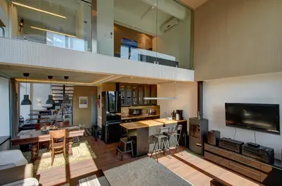 a large living room with a tv and a kitchen at Loft 65 Panoramic View in Vilnius