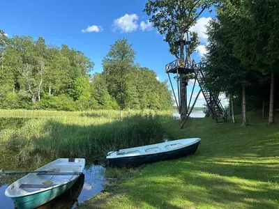 two boats sitting on the shore of a river at Sodyba Ciciriai in Vėdariai