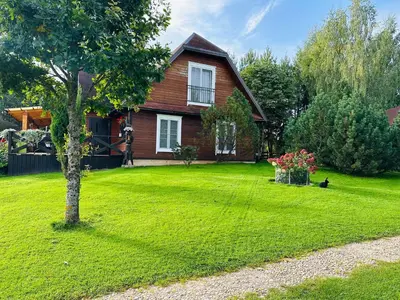 a house with a cat sitting in the yard at Sodyba Ciciriai in Vėdariai