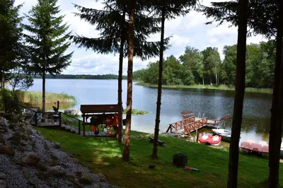 a view of a lake with a boat on the shore at Sodyba Ciciriai in Vėdariai
