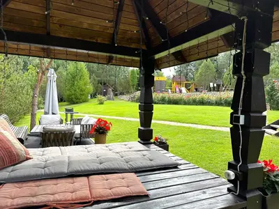 a bed on a patio with a gazebo at Sodyba Ciciriai in Vėdariai