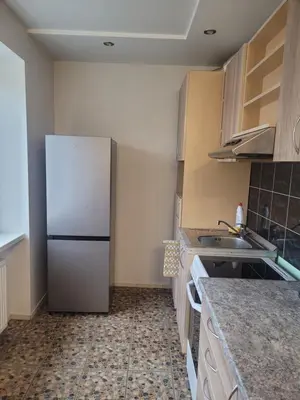 a kitchen with a white refrigerator and a sink at Maironio Apartamentai in Radviliškis