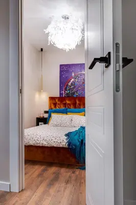 a bedroom with a bed and a chandelier at Lovely apartment Traku str. in Vilnius