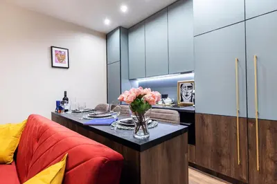 a kitchen and living room with a table with flowers at Lovely apartment Traku str. in Vilnius