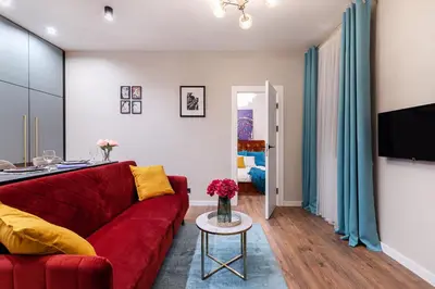 a living room with a red couch and a table at Lovely apartment Traku str. in Vilnius
