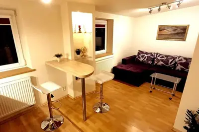 a living room with a table and a couch at Laisves Apartment Kaunas in Kaunas