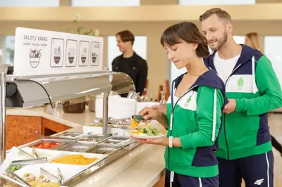 a woman holding a plate of food in a kitchen at Medical SPA 
