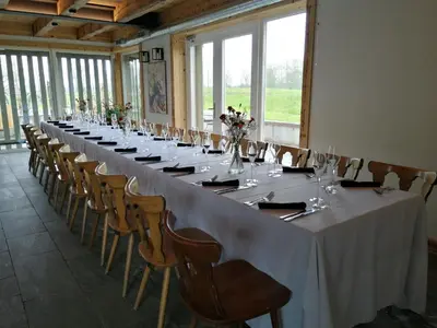 a long table in a room with chairs and tables at Palaima Hotel Anykščiai in Anykščiai