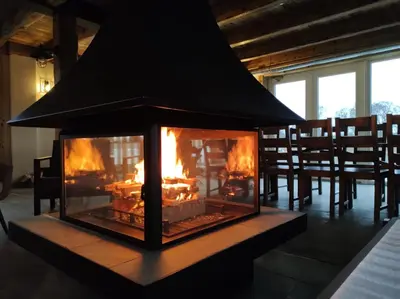 a fireplace in a dining room with fire in it at Palaima Hotel Anykščiai in Anykščiai