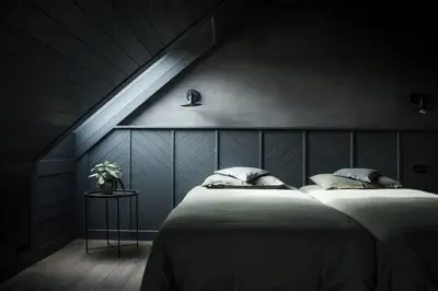 two beds in a dark room with a sloped ceiling at Palaima Hotel Anykščiai in Anykščiai