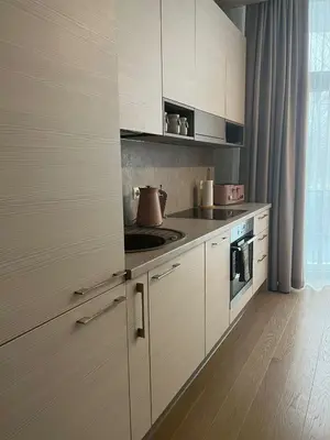 a kitchen with white cabinets and a stove top oven at Pink Peony in Druskininkai