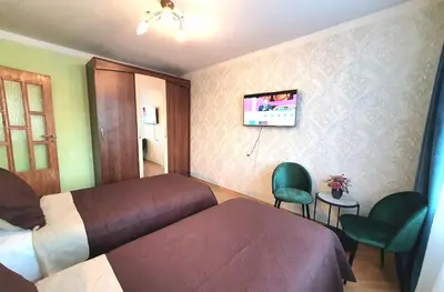 a bedroom with a bed and a tv on the wall at Lovely 2-bedroom Flat in Šiauliai in Šiauliai