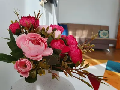 a vase filled with pink flowers on a table at Lovely 2-bedroom Flat in Šiauliai in Šiauliai