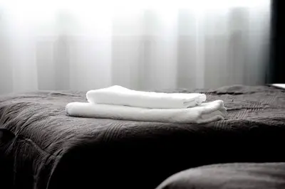 two white towels sitting on top of a bed at Lovely 2-bedroom Flat in Šiauliai in Šiauliai