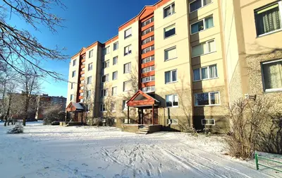a snow covered street in front of a building at Lovely 2-bedroom Flat in Šiauliai in Šiauliai
