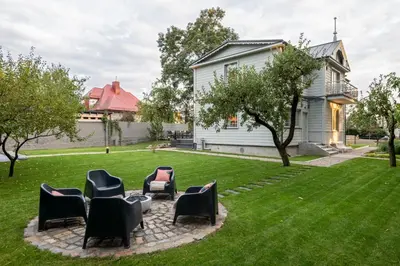 a group of chairs sitting on a lawn at Entire interwar Villa Grabyte by pine forest on the bank of the river- 8min by car from old town in Kaunas