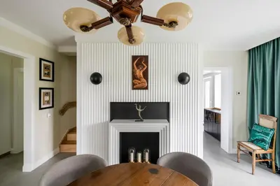 a dining room with a table and a fireplace at Entire interwar Villa Grabyte by pine forest on the bank of the river- 8min by car from old town in Kaunas