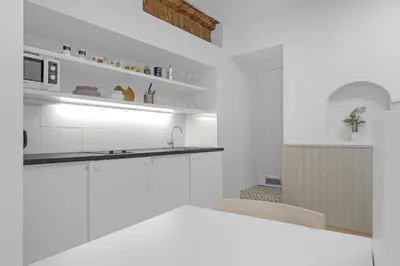 a white kitchen with a sink and a stove at Vilnius Old Town apartment in Vilnius