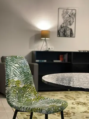 a green chair sitting in front of a table at Jaukus ir kokybiškas butas Panevėžio centre in Panevėžys