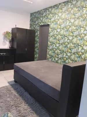 a bedroom with a bed and a floral wall at Jaukus ir kokybiškas butas Panevėžio centre in Panevėžys