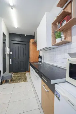 a kitchen with white cabinets and a black door at Jaukus ir kokybiškas butas Panevėžio centre in Panevėžys