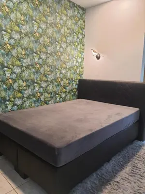 a bed in a room with a floral wall at Jaukus ir kokybiškas butas Panevėžio centre in Panevėžys