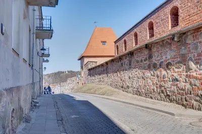 an empty street next to a large brick wall at Mini apartament by Town hall, self chek-in in Vilnius