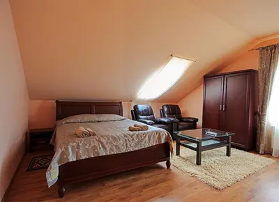 a bedroom with a bed and a table and chairs at El Arm El in Druskininkai