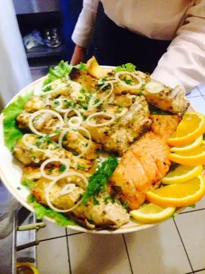a plate of food with seafood and lemon slices at El Arm El in Druskininkai
