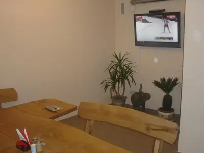 a room with two tables and a tv on the wall at El Arm El in Druskininkai