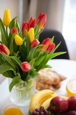 a vase filled with red and yellow flowers on a table at #stayhere - Modern & Central Studio Apartments in Vilnius