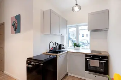 a kitchen with white cabinets and a black dishwasher at #stayhere - Modern & Central Studio Apartments in Vilnius